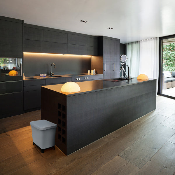 Moderne Küche mit dunklen Schränken, integrierten Geräten und einer Insel mit Pendelleuchte und einem YourCasa® Mülltrennsystem mit 2-4 Fächern [20-40L] – Effiziente Mülltrennung mit exklusivem Design von yourcisade.com.