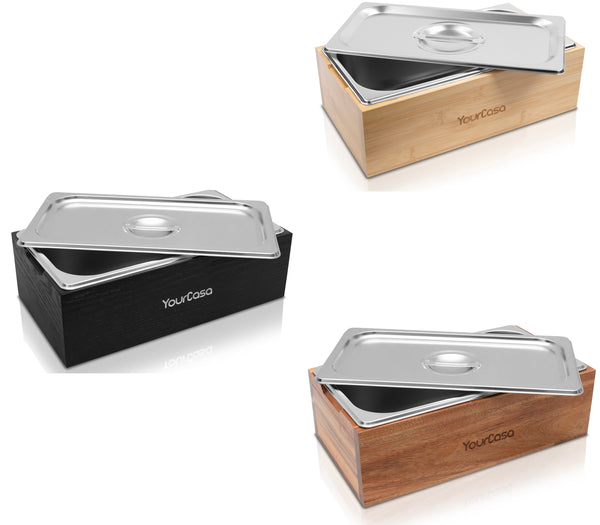 Drei YourCasa® Komposteimer aus Echtholz und Edelstahl mit Metalldeckeln in den Ausführungen Schwarz, Natur und Braun werden nebeneinander ausgestellt. Jeder Komposteimer ist auf der Vorderseite mit dem Logo „yourcisade.com“ versehen.