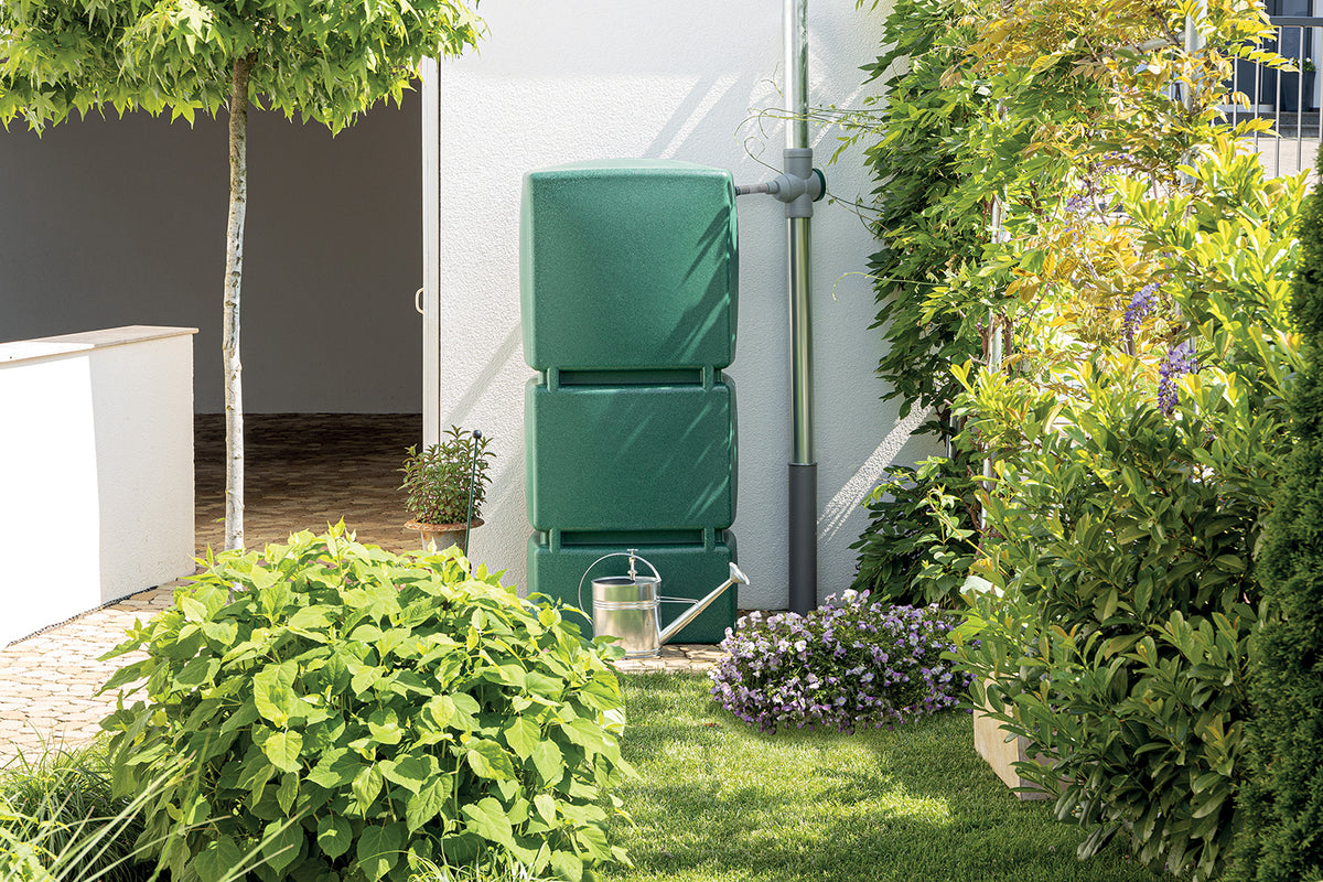 Regenwassersammelsystem mit einer YourCasa Regentonne 800 Liter [AquaGiant] und Gießkanne in einer privaten Gartenanlage.