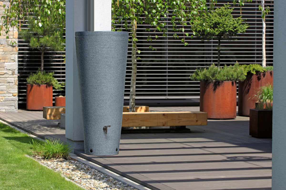 Ein großer Pflanzkübel auf einer Terrasse, gefüllt mit Tubo-Tank 320 Liter – Robuste Regentonne mit großem Fassungsvermögen und stilvollem Design von yourcisade.com.